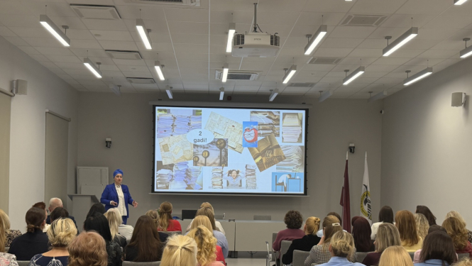 Auditorija ar mācību dalībniekiem, pasniedzēju