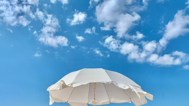 krēsli un saulessargs pludmalē