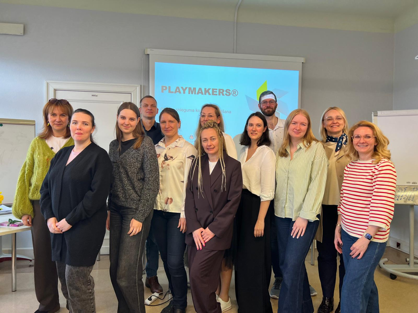 Mācību dalībnieku un pasniedzēja kopbilde mācību telpā