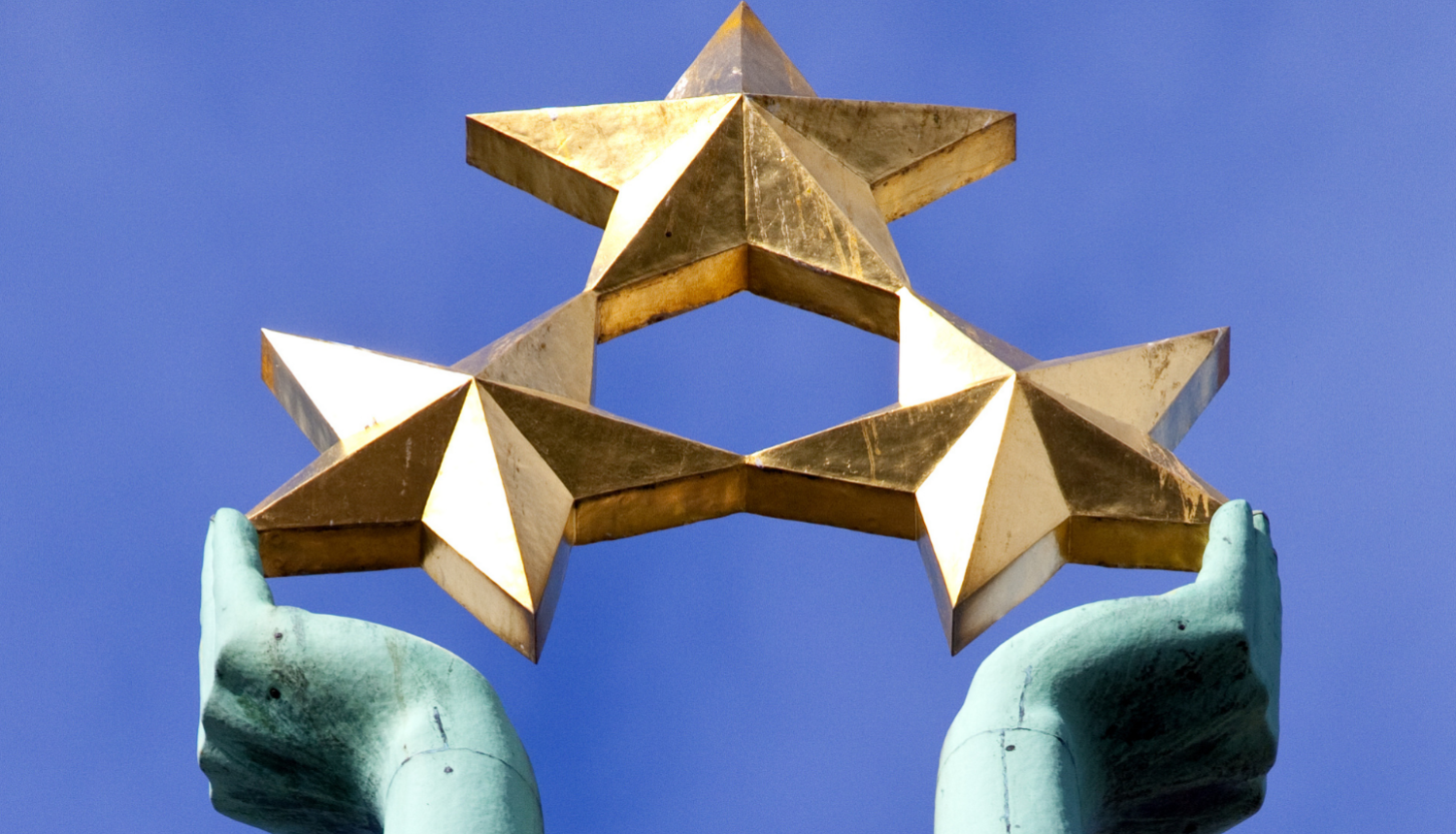 Brīvības pieminekļa sievietes rokas, kur tur rokās trīs zelta zvaigznes.